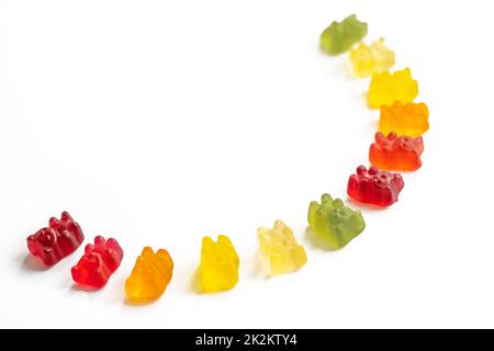 Mehrfarbige Gummibären liegen in einem Halbkreis auf einem hellen Hintergrund mit negativem Abstand, Draufsicht Stockfoto