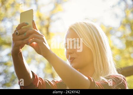 Das Bild einer jungen Frau, die ein Selfie macht Stockfoto