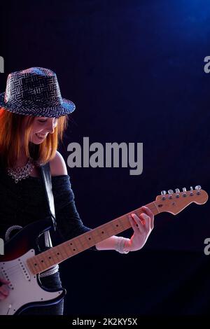 Hipster, trendige, junge Musikerin, die Gitarre spielt Stockfoto