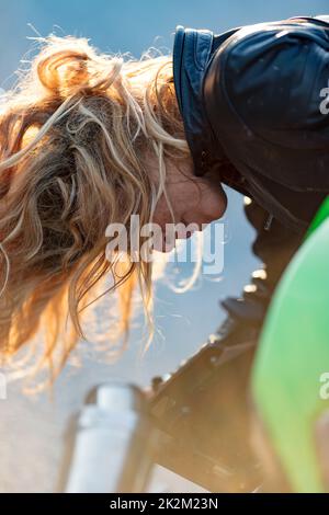 Eine Frau, die ihr Motorrad zum Laufen bereitete Stockfoto