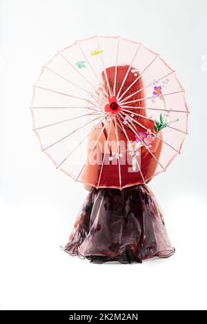 Junge Tänzerin hinter einem roten chinesischen Regenschirm Stockfoto