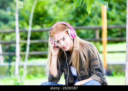 Attraktive junge Frau, die Musik hören Stockfoto