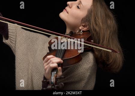 Leidenschaftliche Violinistin, die Barockgitarre spielt Stockfoto