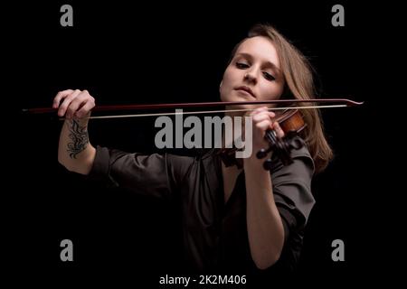 Leidenschaftlicher Geigenmusiker, der auf schwarzem Hintergrund spielt Stockfoto