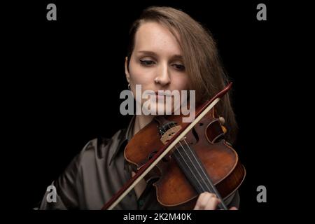 Eine engagierte Frau, die eine barocke Geige spielt Stockfoto