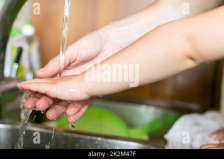 Hände von Baby und Frau unter Wasser Stockfoto