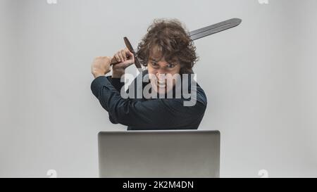 Wütender Mann, der kurz davor ist, seinen Laptop zu zerstören Stockfoto