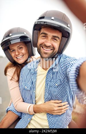 Momente wie diese lohnen sich einzufangen. Ausgeschnittene Aufnahme eines liebevollen Paares, das draußen Selfies macht. Stockfoto