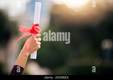 Die beste Möglichkeit, die Zukunft vorherzusagen, ist, sie zu schaffen. Ausgeschnittene Aufnahme einer unerkennbaren jungen Studentin, die am Abschlusstag feiert. Stockfoto