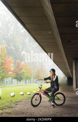 Junge aktive Frau auf dem Freestyle-Bike Stockfoto