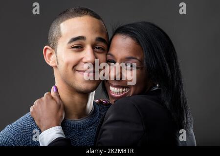 Stolze Mutter umarmt seinen lächelnden Sohn Stockfoto