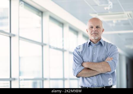 Der Blick eines nachdenklichen Senior-Geschäftsmannes aus dem unteren Winkel Stockfoto
