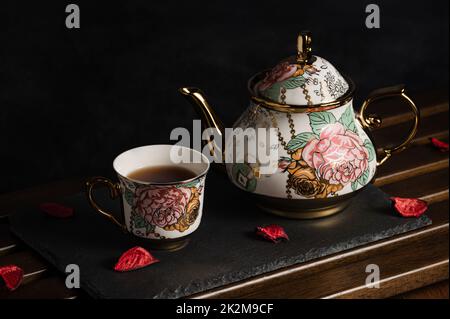 Afternoon-Tea-Image mit schwarzem Tee und schöner Teekannen und Tasse an Bord Stockfoto