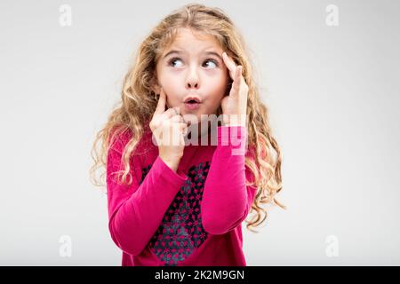 Lustiges, verspieltes kleines Mädchen mit einem ärgerlichen Ausdruck Stockfoto