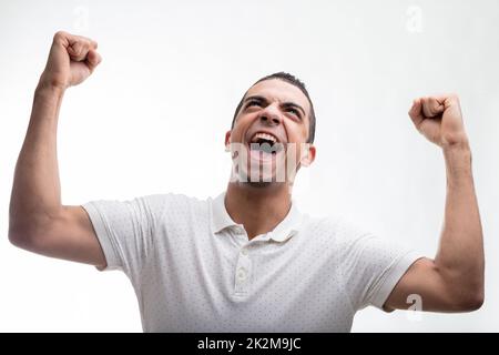 Aufgeregter Mann, der jubelt und in die Luft schlägt Stockfoto