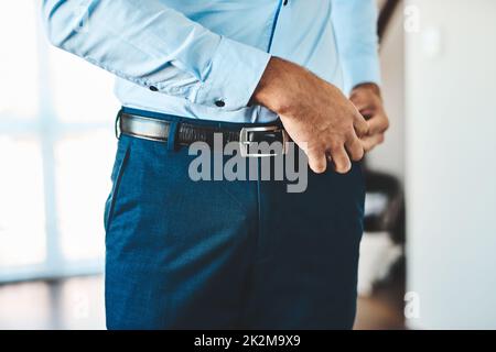 So fällt meine Hose nicht ab. Kurzer Schuss eines unkenntlichen Mannes, der sich zu Hause in seinem Schlafzimmer kleidete. Stockfoto