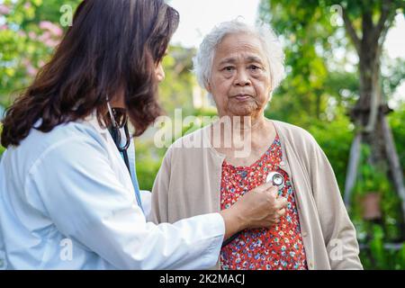 Arzt Hilfe Asian ältere Frau Behinderung Patient gehen mit Wanderer im Park, medizinisches Konzept. Stockfoto