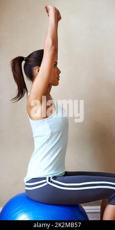 Mit Pilates in guter Verfassung bleiben. Aufnahme einer jungen Frau, die zu Hause Pilates macht. Stockfoto