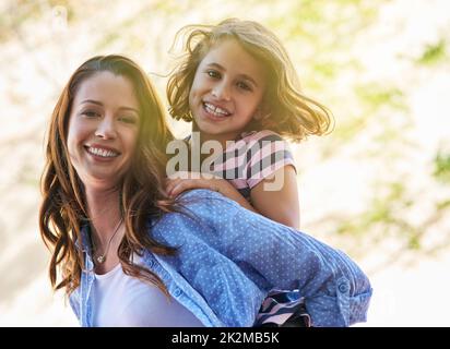 Glückliche Mädchen sind die hübschesten. Aufnahme einer Mutter, die ihrer Tochter eine Huckepack-Fahrt gab. Stockfoto