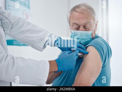 Der Jab. Kurzer Schuss eines hübschen älteren Mannes, der seinen covid 19-Impfstoff erhalten hat. Stockfoto