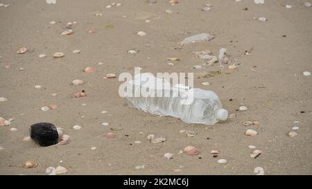 Verschmutzung durch Plastik. Leere Plastikflasche am Strand. Verschmutzungskonzept. Abfall leere Getränkepakete weggeworfen Stockfoto