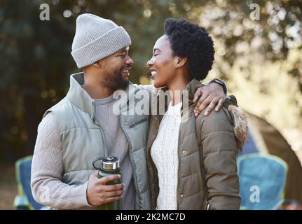 Wir sollten dies öfter tun. Aufnahme eines jungen Paares, das beim gemeinsamen Campen liebevoll ist. Stockfoto