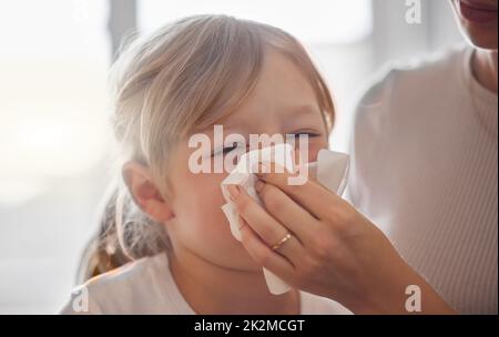 Wir haben das den ganzen Tag gemacht. Aufnahme einer Mutter, die zu Hause ihre kleinen Mädchen mit einem Gewebe im Bett abwischt. Stockfoto