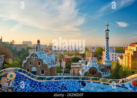 Blick auf die Stadt Barcelona vom Parc Güell. Blick auf das farbenfrohe Mosaikgebäude im Park Güell bei Sonnenaufgang Stockfoto