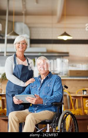 Es gibt nichts anderes, das wir lieber haben. Porträt zweier leitender Unternehmer, die während der Arbeit in ihrem Café zusammen ein Tablet betrachten. Stockfoto