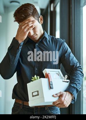 Das kann mir nicht passieren. Aufnahme eines unglücklichen Geschäftsmannes, der seine Schachtel mit Habseligkeiten in der Hand hielt, nachdem er von seinem Job entlassen wurde. Stockfoto