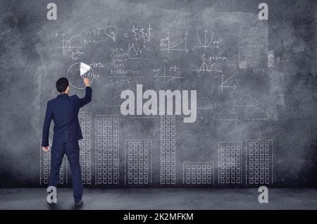Business Analysts..Genies der Unternehmenswelt. Eine Rückansicht eines Geschäftsmannes, der Berechnungen auf schwarzem Hintergrund durchführt. Stockfoto