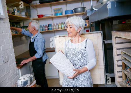 Zuhause ist, wo die Kunst ist. Aufnahme eines älteren Ehepaares, das in einer Werkstatt mit Keramik arbeitet. Stockfoto