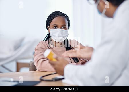 Den Anweisungen des Arztes zuhören. Aufnahme einer jungen Frau, die während einer Konsultation Medikamente von einem Arzt erhält. Stockfoto