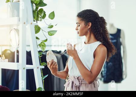 Ich Frage mich, ob diese Geldbörse zu meinem Outfit passt. Aufnahme einer attraktiven jungen Frau auf einem Einkaufsbummel in einer Boutique. Stockfoto