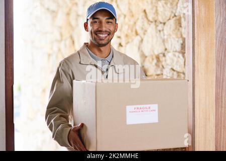 Ich liefere immer pünktlich. Ein Porträt eines hübschen jungen Mannes, der Ihr Paket ausliefert. Stockfoto