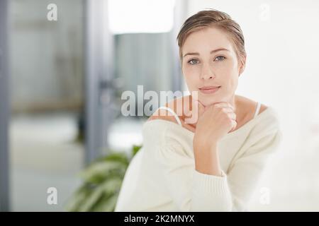 Glücklich zu sein geht nie aus dem Stil. Porträt einer lächelnden jungen Frau allein zu Hause. Stockfoto