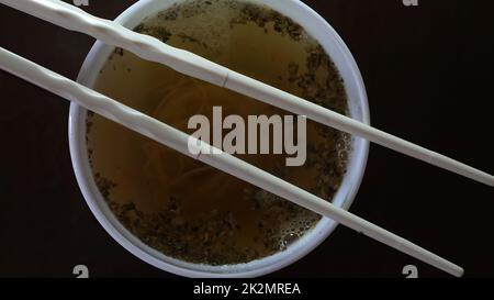 Nahaufnahme von Instant Nudeln gelben Ramen und chinesischen Essstäbchen Stockfoto