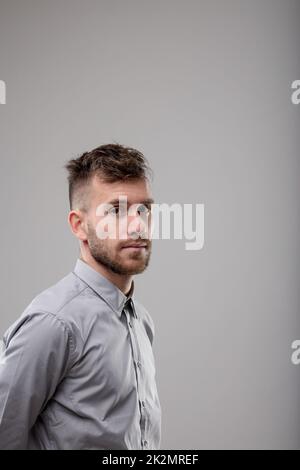 Ein bärtiger Mann, der seitwärts in die Kamera schaut Stockfoto