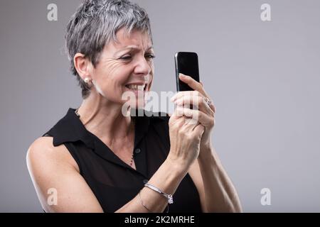 Frustrierte Frau, die sich die Zähne kaut Stockfoto