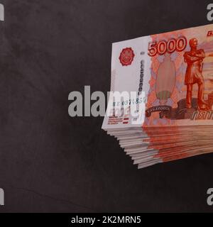 Russischer Rubel mit einem großen Bündel auf grauem Hintergrund. Ein Bündel 5000 Rubel-Noten. Stockfoto