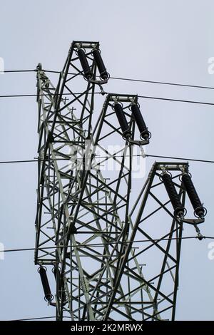 Die Stahlstange von einem Kraftpfosten. Die Stromleitungen werden von einem Metallmast gehalten. Stockfoto