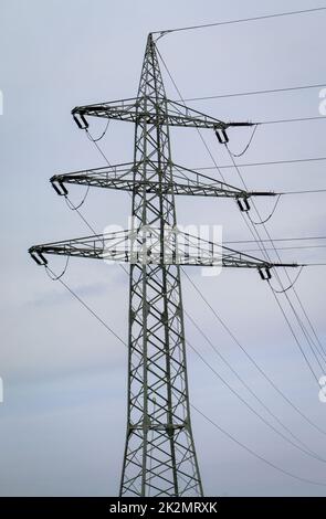 Die Stahlstange von einem Kraftpfosten. Die Stromleitungen werden von einem Metallmast gehalten. Stockfoto