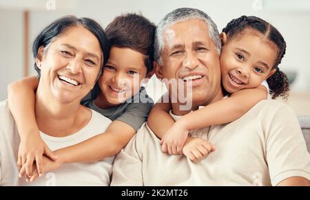 Enkelkinder umarmen Großeltern für Liebe, Pflege und Entspannung in Familie zu Hause zusammen. Porträt von glücklichen Kindern, lächeln ältere Oma und lachen ältere Menschen Stockfoto