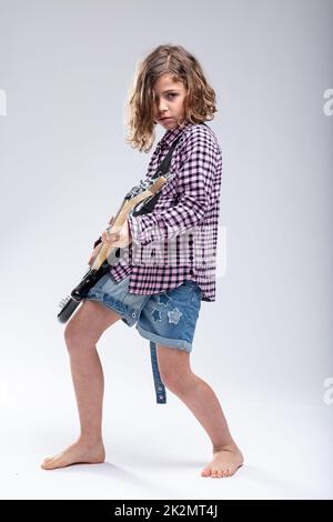 Begabtes junges Schulmädchen, das elektrische Gitarre spielt Stockfoto