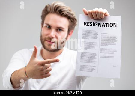 Porträt eines glücklichen Mitarbeiters mit dem formellen Kündigungsschreiben Stockfoto