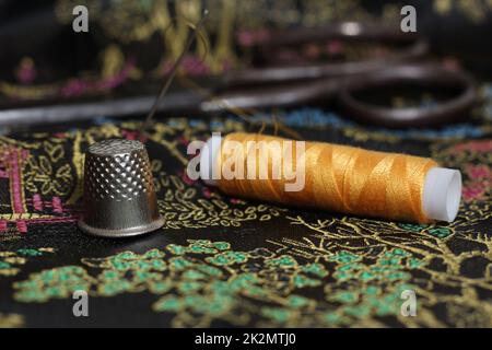 Gelbes Faden und Kaugummi auf klassischer chinesischer schwarzer Seide Stockfoto