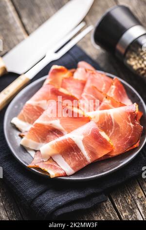 In Scheiben geschnittener schwarzwald-Schinken. Getrockneter Prosciutto-Schinken auf dem Teller. Stockfoto