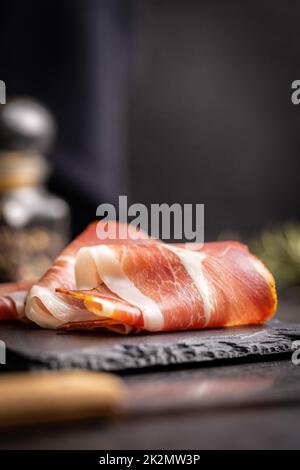 In Scheiben geschnittener schwarzwald-Schinken. Getrockneter Prosciutto-Schinken auf Schneidebrett. Stockfoto