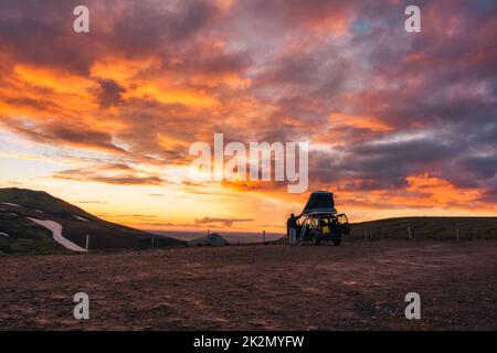 Tourist Camper Auto geparkt mit schönen Sonnenuntergang Himmel auf dem Gipfel des Berges in isländischen Highlands im Sommer auf Island Stockfoto