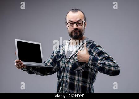 Erfolgreicher, zufriedener Mann, der Daumen nach oben gibt Stockfoto